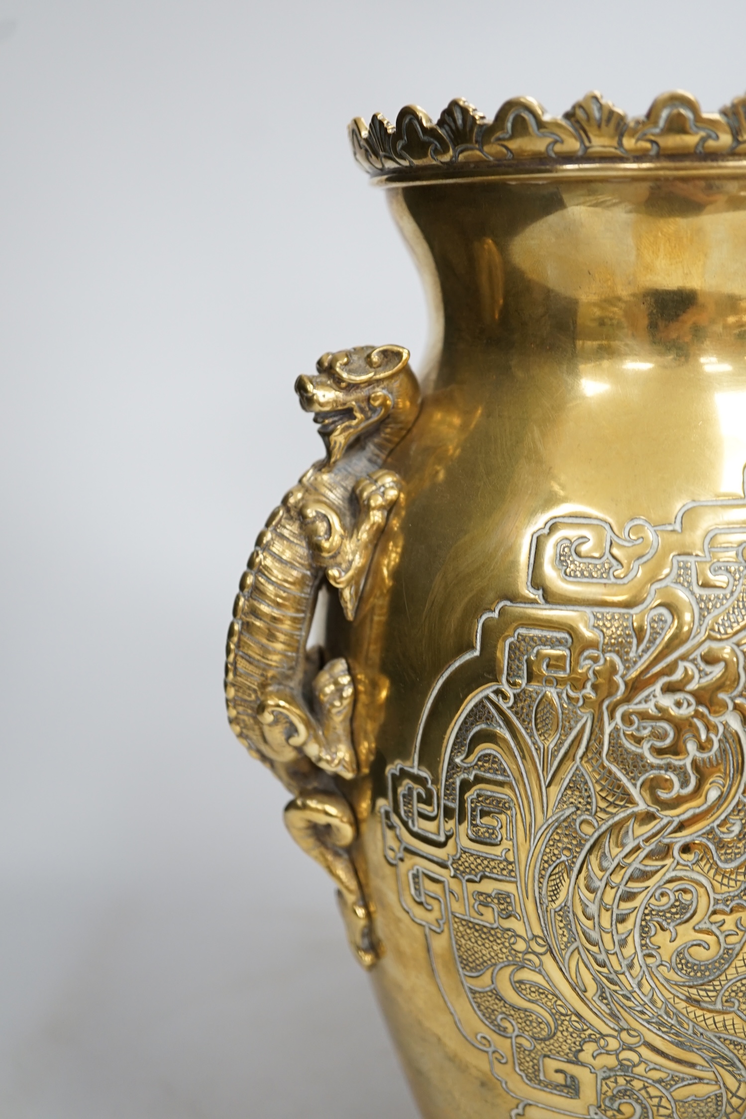 A Chinese dragon handled brass vase with ornate stand, 34cm high. Condition - the base to vase is missing